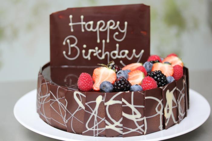 šokoladinis gimtadienio tortas, švieži vaisiai ir raižytas šokoladinis pyragas du sluoksniai ir užrašas
