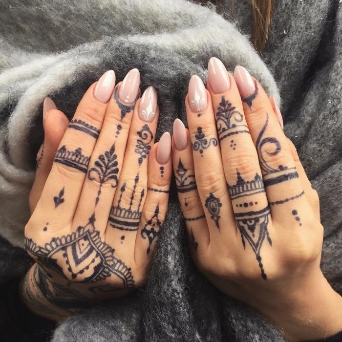 tetovaže s kano, roke počivajo na sivem rutu, z golim lakom za nohte, tetovažami z majhnimi prsti