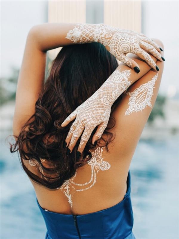 oblikovanje tetovaže kane na hrbtu in rokah z belo cvetlično čipko in zvitki z vzorci kane, dolgimi kodrastimi lasmi