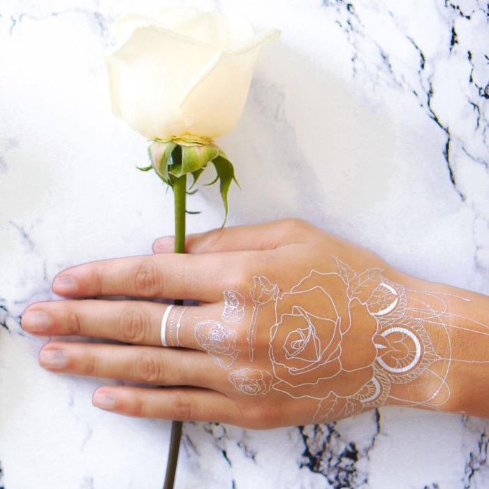 chna tatuiruotės idėja ant rankų ir pirštų su gėlių motyvais, maža laikina tatuiruotė ant piršto su brangakmenio efektu