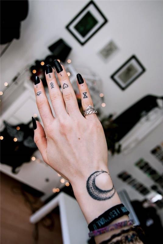 roka z različnimi tetovažami na vsakem prstu, črni lak za nohte, tetovaža prstov, okvirji za slike v ozadju