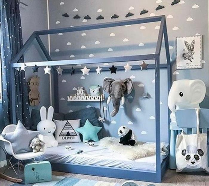 Montessori metodo kūdikio kambarys pilkoje, debesų apdaila, pilka žaidimų kambario lova, baltas čiužinys, žaislai, skandinaviška supama kėdė, žaislas panda, drambliai, triušis, pagalvėlės