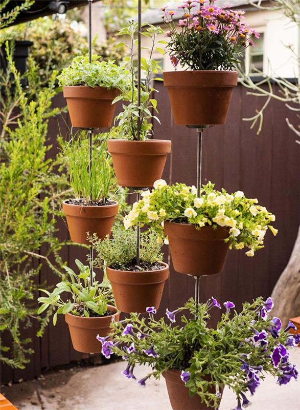 ideja, kako narediti vrtni vetrič z visečimi rastlinami terakotne cvetlične lončke v rastlinski zavesi ločitev zasebnost vrt