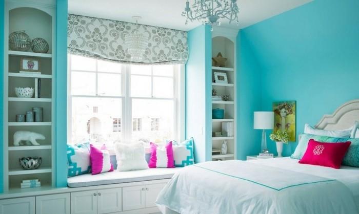 turkizna spalnica, kristalni lestenec, roza blazine, kipci, turkizne stene