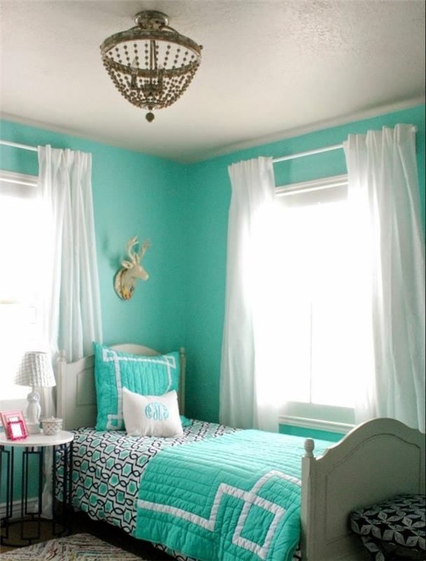 turkizna spalnica, večbarvna preproga, bele zavese, nočna svetilka, turkizna posteljna prevleka