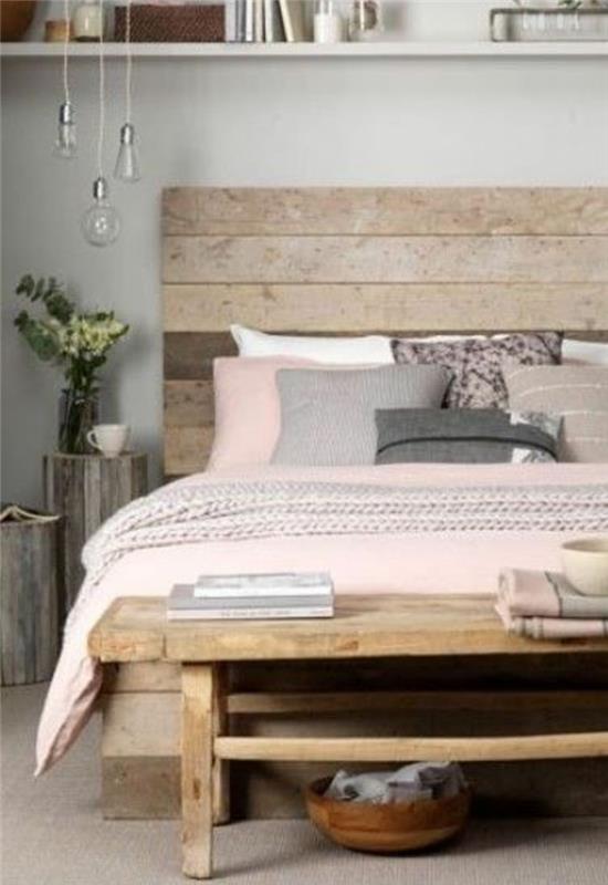 ideja za okrasitev spalnice, lesena postelja, leseni konec postelje, rožnati posteljni komplet, roza in sive blazine, lesni hlodi kot nočne omarice, barve za spalnico za odrasle