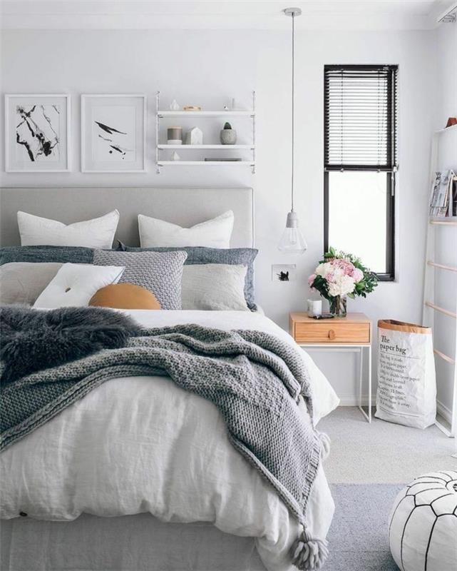 pilkas miegamasis, modernaus skandinaviško stiliaus miegamojo dekoras, pakabinama lempa, paveikslų rėmai, medinė ir balta lova