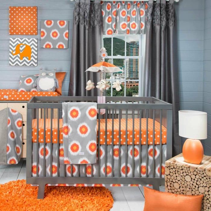 mišri kūdikio kambario dekoravimo idėja, apvalus kilimas, oranžinė odinė pagalvėlė, originalūs tapetai