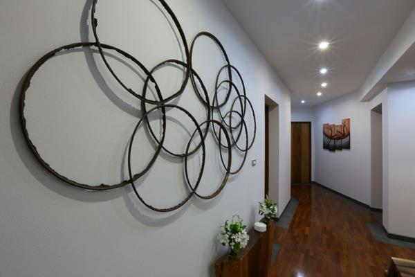dekorativni-hodnik-ideja-stenska instalacija-z obročki-majhna polica-s cvetjem