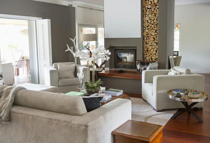 modernios svetainės dekoro idėja, dekoratyvinis rąstinis stovas, pilkos sofos, medinės grindys, didelės sofos