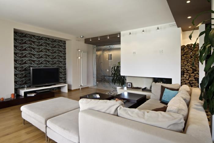modernios svetainės deko idėja, didelė modulinė sofa, medžio efekto grindys, kelios lempos, sumontuotos ant lubų, dekoratyvinis rąsto laikiklis