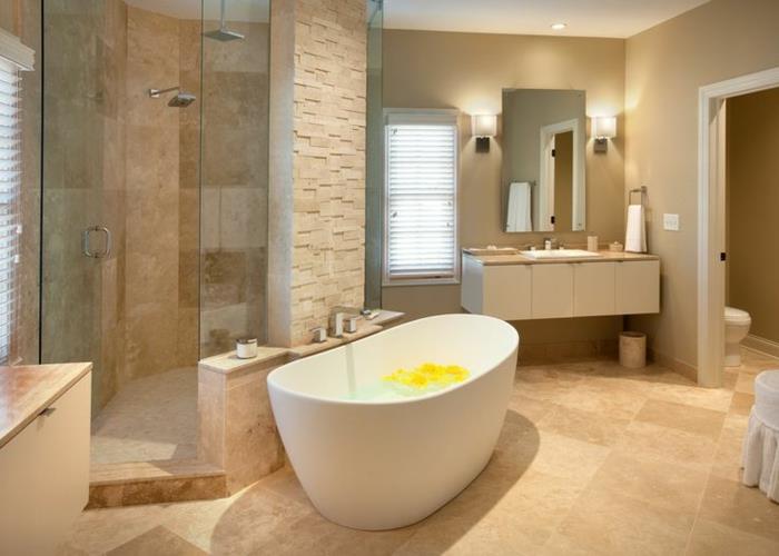 travertenli banyo dekor fikri, güzel oval şekilli küvet, küçük asılı ayna, duş alanı