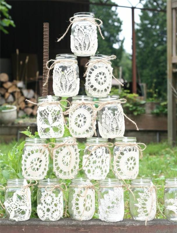 ideja poročne dekoracije s steklenimi kozarci, prilagojenimi belimi čipkami in vrvicami, dekorativno rustikalno elegantno poročno kompozicijo