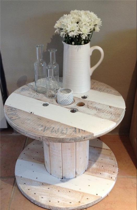 elegantna dekoracija podeželske dnevne sobe, lesena miza s kolutom in belimi barvnimi črtami, šopek belih rož v vazi, okrasne steklenice