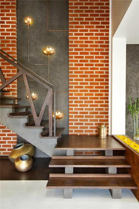 įėjimo idėja oranžinė plytų siena ir laiptai su bronzos spalvos metaliniais laipteliais, dekoratyviniai elementai su bronzinėmis metalinėmis gėlėmis