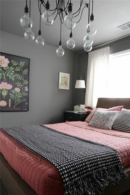 siva stenska barva, oblikovalska svetilka, posteljnina lososove rožnate barve, stenska dekoracija s cvetličnim vzorcem, roza in siva spalnica