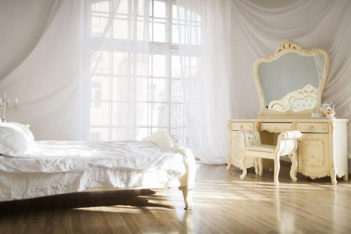 ideja za okrasitev spalnice, veliko karirano okno, bele tančice, zlati svečniki, parket iz svetlega lesa
