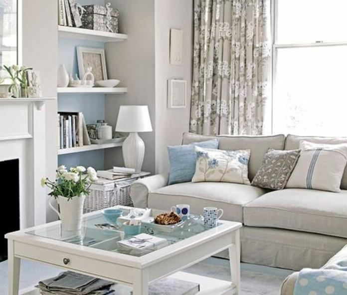 Mobili soggiorno moderni, parete di colore blu con mensole, tavolino basso di legno e vetro