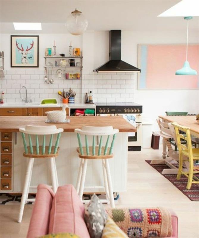 Cucina su atvira erdve soggiorno ir sala da pranzo con cuscini colorati e pareti bianche