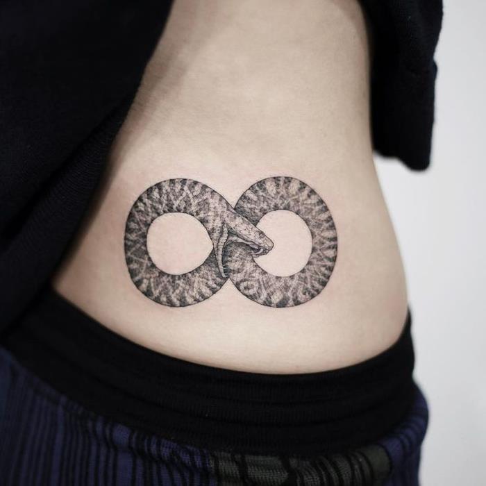 Geometrinė tatuiruotė su simbolo dell'infinito di un serpente che morde sul corpo di una ragazza