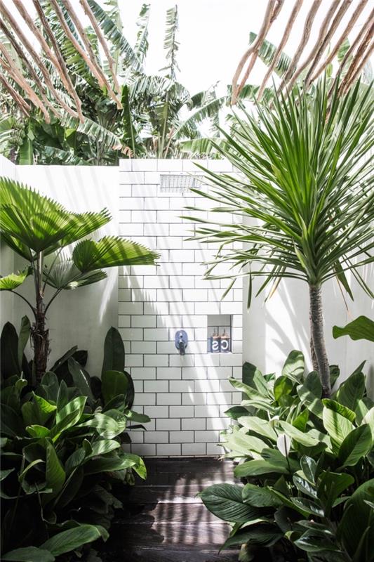 egzotik ahşap çatılı ve beyaz kiremit duvarlı bir açık hava banyosunun nasıl dekore edileceğine örnek