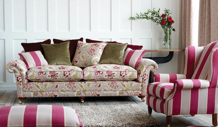 sodobna postavitev dnevne sobe, beli in malinovo roza naslanjač in stolček, siva preproga, siva kavč s cvetličnim potiskom, zelene, bordo in malinove blazine