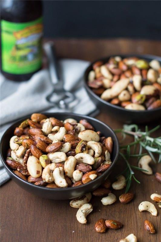 arkadaşlarla basit bir akşam yemeği aperitifi fikri, peynir tabağına eşlik etmek için bir kasede servis edilen lezzetli baharatlı fındık karışımı