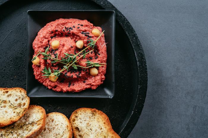 Kekik dalları ve siyah susam tohumları ile ev yapımı pancar humus dekorasyonu, aile aperitifi