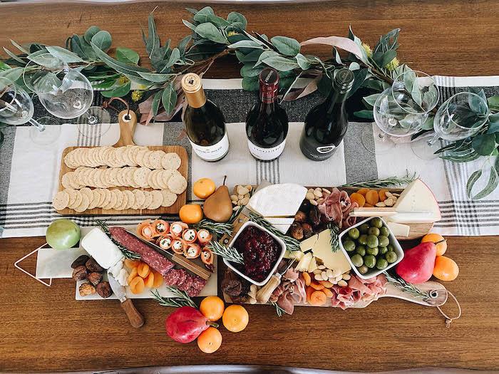 ideja za večerjo z aperitivom pladenj s hladnim mesom na leseni mizi, okrašeni s potjo iz blaga in zelenimi vejami