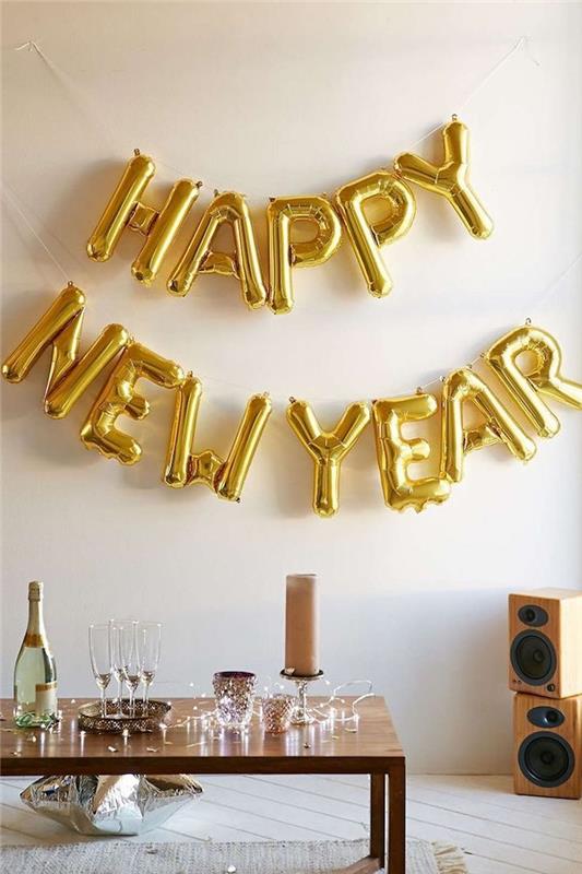 harflerle balon altın mutlu yeni yıl, ahşap sehpa ve hafif çelenk dekorasyonu, gümüş yıldız şeklinde balon