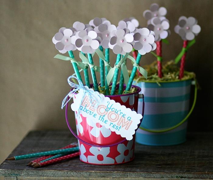 Dekoratif bir kovada kağıt çiçeklerin üzerine süslenmiş kalemlerle kendinizi yapmak için okula dönüş metresi hediye fikri