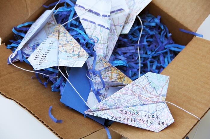 sulankstomas origami lėktuvas į kelių žemėlapį, kad būtų sukurta originali šventinė girlianda