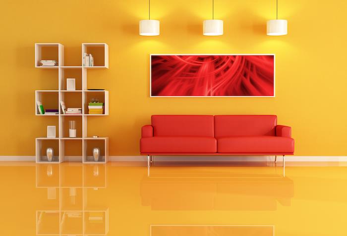 rdeča zofa v rumeni dnevni sobi, lesena polica, rumena stena in tla, beli viseči svetilki, preprosto oblikovana dekoracija dnevne sobe