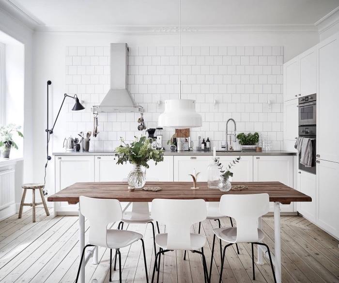 İskandinav mutfak dekoru, mutfak ön ve beyaz fayans, ham ahşap yemek masası ve İskandinav beyaz sandalyeler, hafif ahşap parke, paslanmaz çelik tezgah