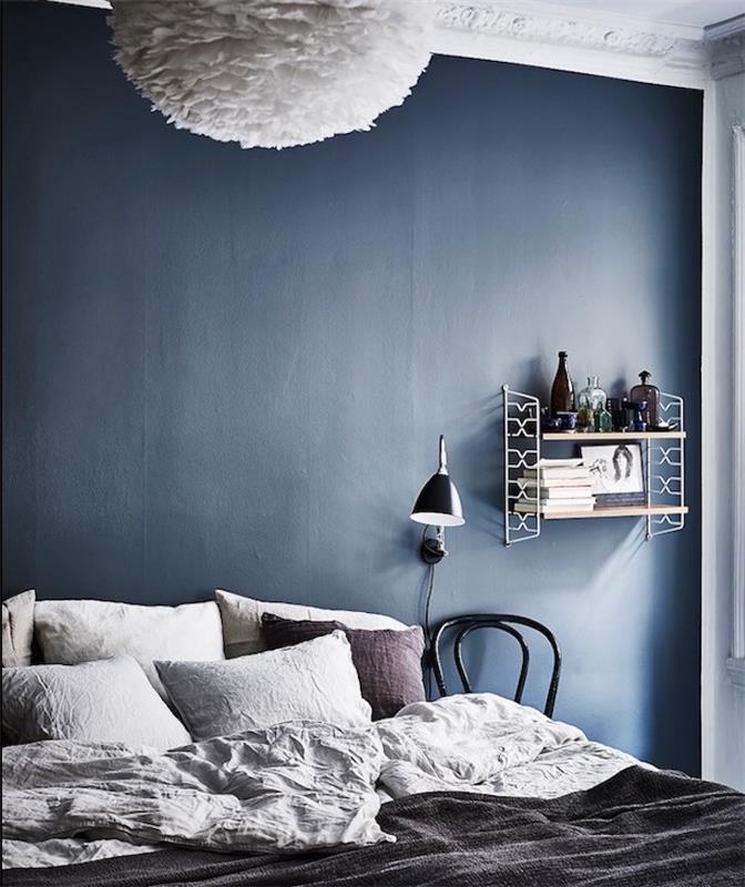 temno modra dekoracija spalnice za odrasle kot barva stene, sivo posteljnina, vintage dizajn polica, bela viseča svetilka