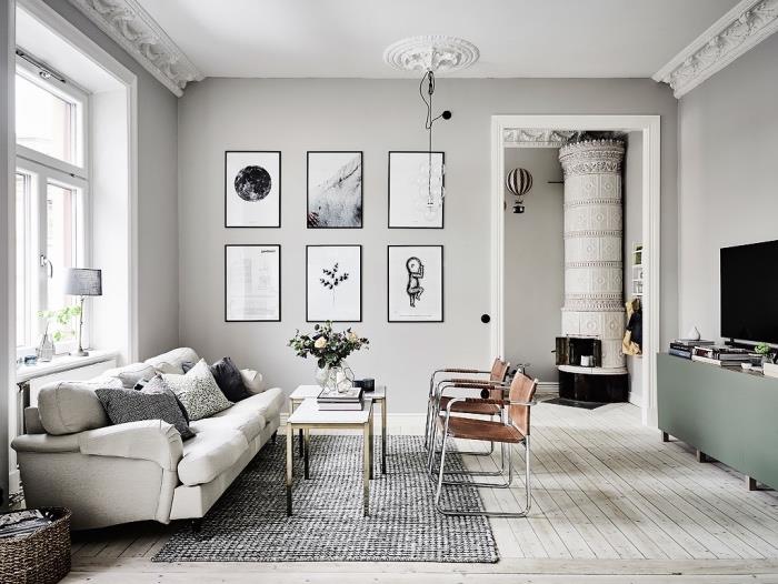 iskandinav oturma odası düzeni, gri duvar ve kanepe rengi, kahverengi sandalyeler, gri halı, sehpalar, pastel yeşil tv dolabı, grafik duvar dekorasyonu