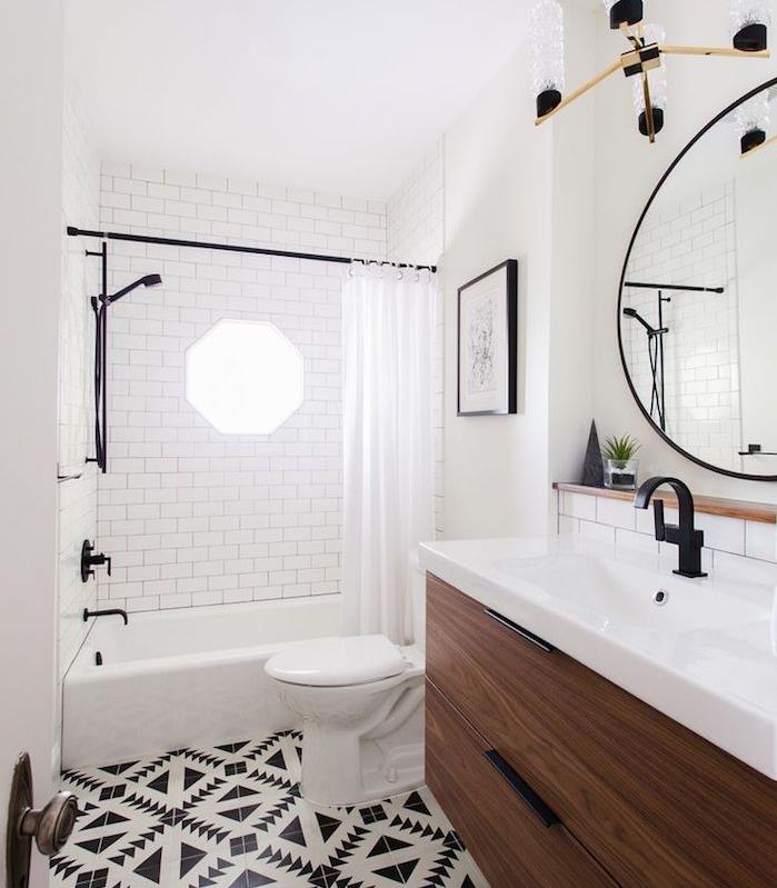 beyaz lavabolu küçük ahşap banyo dolabı, büyük yuvarlak ayna, duş perdeli küvet, siyah beyaz yer karoları