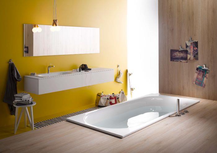 rumena barva stene za kopalnico s pravokotnim ogledalom in belo omarico, lesena talna obloga, kad, vgrajena v tla