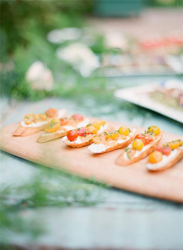 crostini recepto idėja su grietinėlės sūriu ir marinuotais vyšniniais pomidorais ant šalies savitarnos patiekimo padėklo originalios idėjos