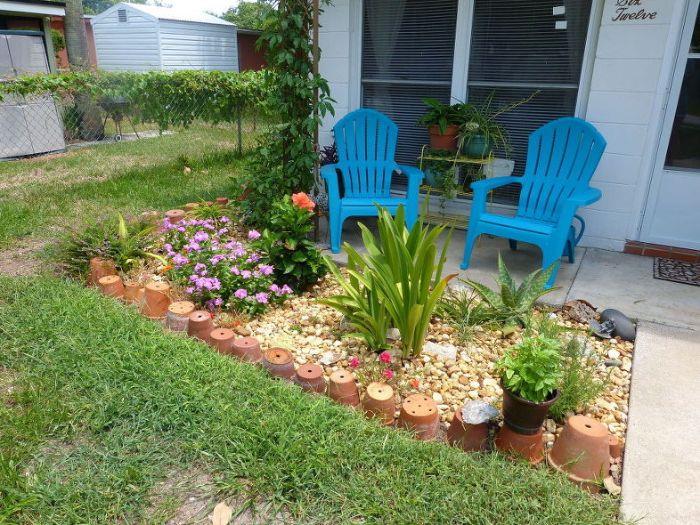 DIY dekoracija za okrasitev vašega vrta s lončki iz terakote na gramozu, urejanje cvetličnih gredic pred hišo