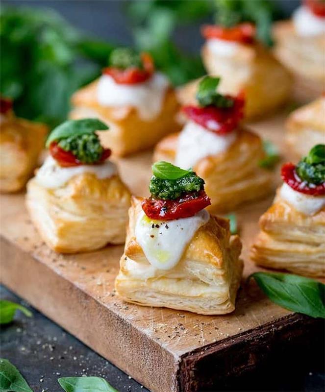 peynir, pesto ve kurutulmuş domates caprese stili ile küçük puf böreği kareler, aperatif için hızlı meze