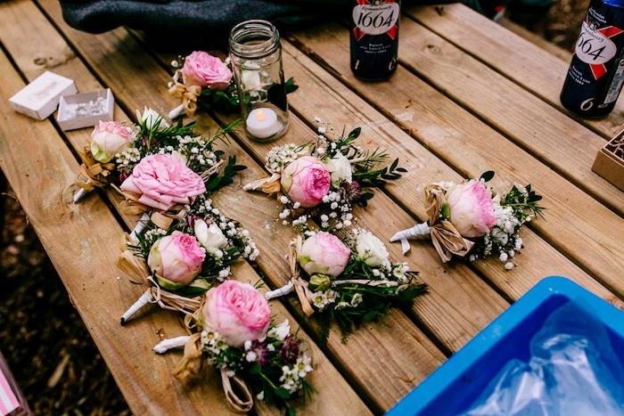 kmečko poročno cvetje, primer elegantnega boutonniera, na leseni mizi, svečnik v steklenem kozarcu