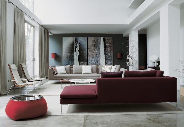 bordo spalvos sofa su betoninėmis grindimis, beveik baltas kilimas, pilka sofa, originalios kėdės, pilka akcentinė siena, dekoratyvinės plokštės, lizdai
