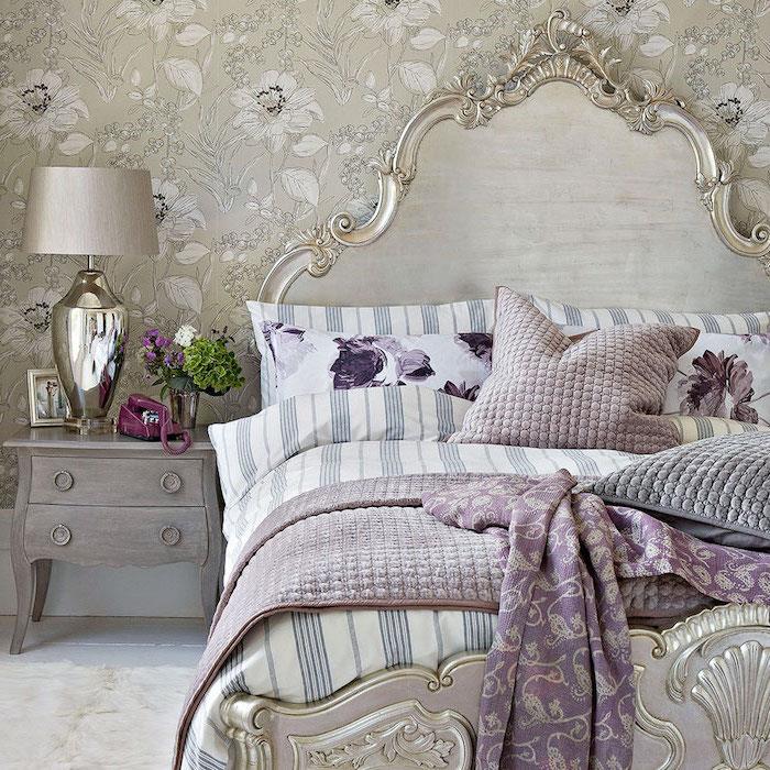 kaip įrengti barokinį miegamąjį, barokinę lovą, pilkai nudažytą spintelę su nusidėvėjusia išvaizda, baltą, pilką ir purpurinę patalynę, baltus ir pilkus tapetus su gėlių raštu