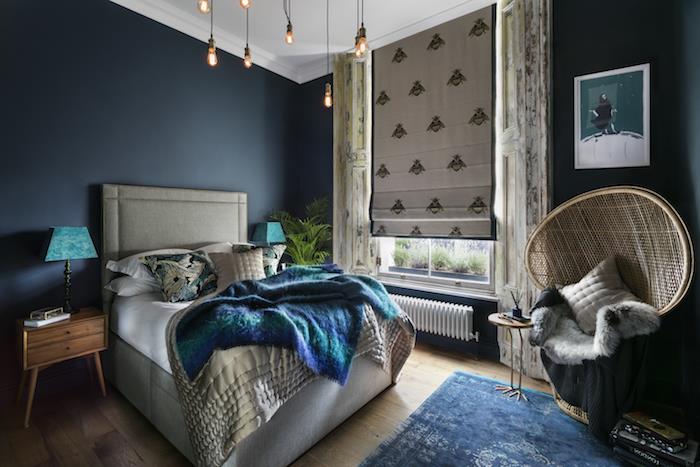 barva spalnice za odrasle mornarsko modra, siva postelja z račjo modro odejo, orientalski naslanjač, ​​lesena nočna omarica