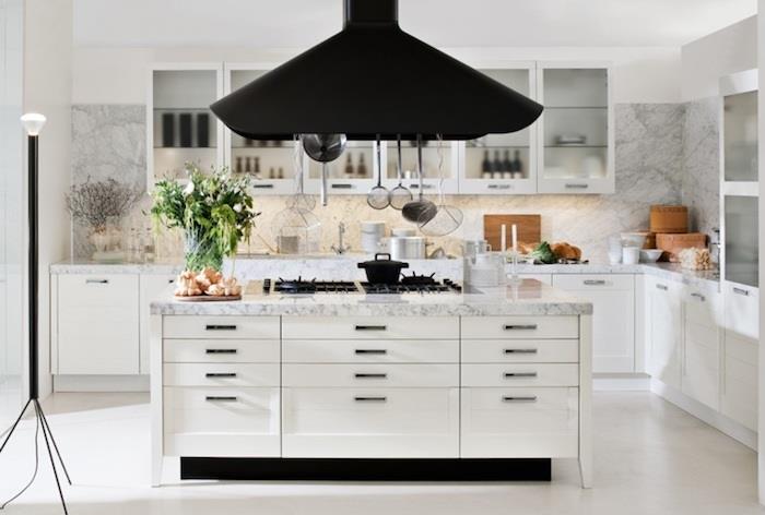 L formos virtuvės idėja su baltais virtuvės baldais, marmuriniu stalviršiu, balta centrine sala, eksponuojamais indais ir indais
