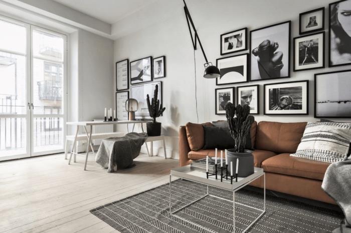 Kahverengi kanepe, gri halı, hafif parke, beyaz masada yemek alanı tezgahı, siyah beyaz fotoğraf duvar dekorasyonu ile grafik siyah beyaz İskandinav oturma odası
