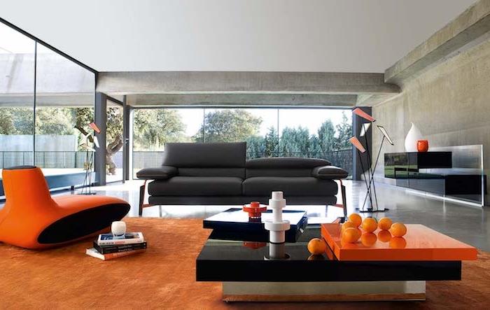 açık boz renkli duvarlar, turuncu halı ve tasarım koltuk, modern siyah ve turuncu sehpa, antrasit gri kanepe