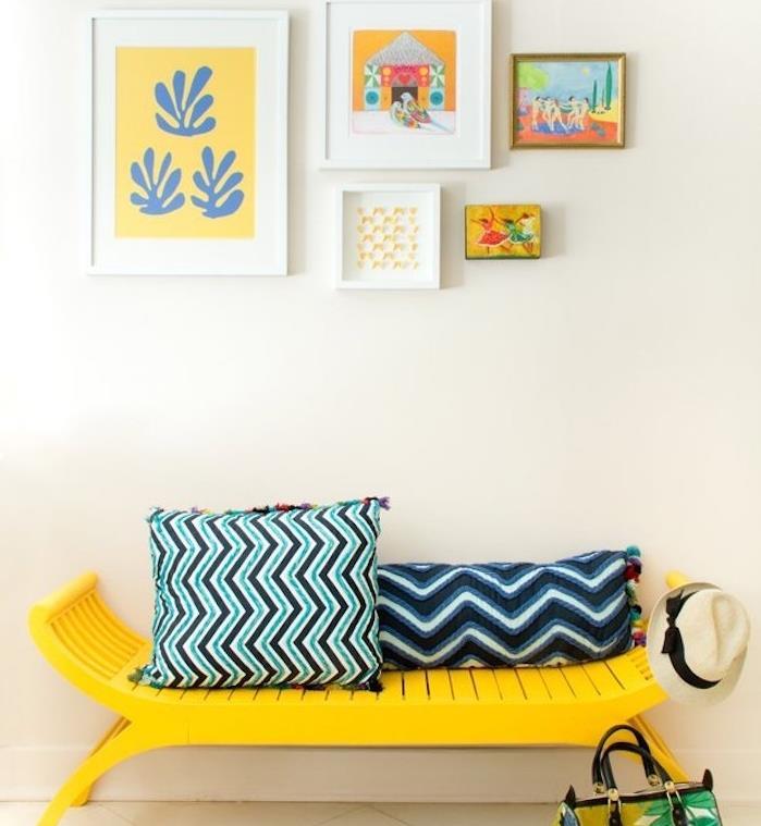 bir mobilyayı sarıya boyamak, kişiye özel bir tezgah ve geometrik desenli mavi ve siyah minderler, duvarda dekoratif çerçeveler