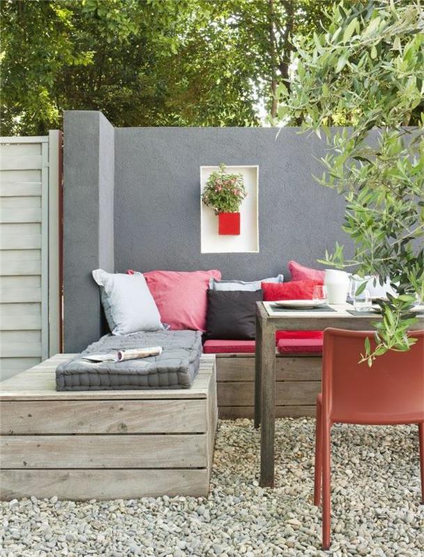 gri boyalı bir duvarla kırmızı, beyaz ve siyah renklerde minimalist tarzda bir bahçe nasıl düzenlenir